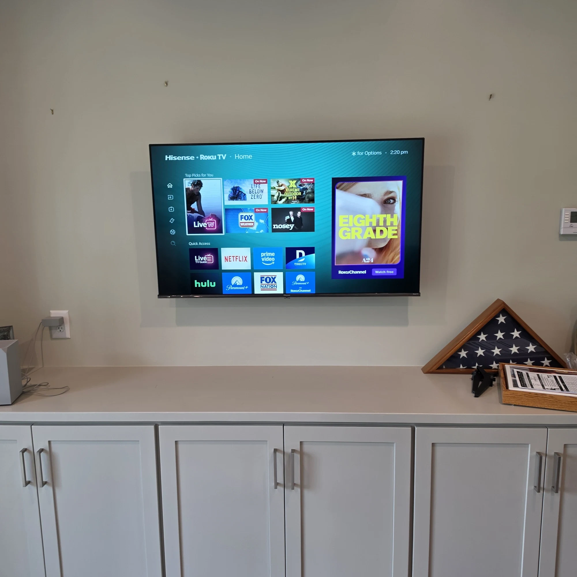 Living room TV wall mounted above a cabinet